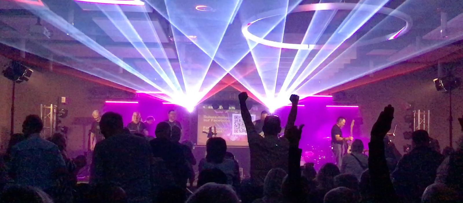 The stage under the lasers, the crowd with hands raised